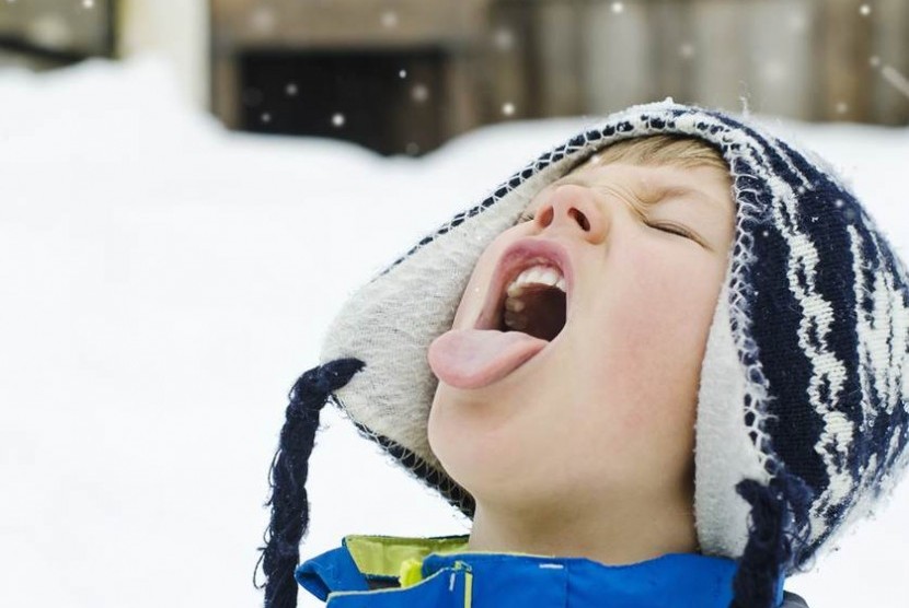 Seorang anak memakan salju