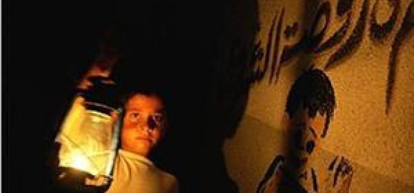 Seorang anak membawa lentera dalam krisis listrik di Gaza.