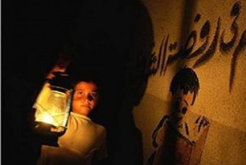 Seorang anak membawa lentera dalam krisis listrik di Gaza.