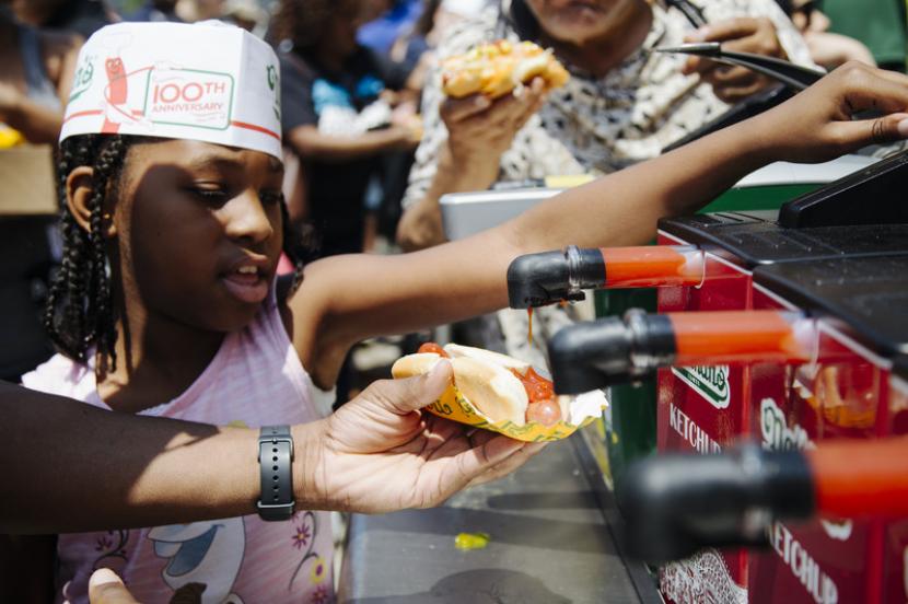 Seorang anak memberikan saus pada hotdog (Ilustrasi). Untuk mencegah tekanan darah tinggi, gunakan saus dalam masakan atau makanan seperlunya saja.
