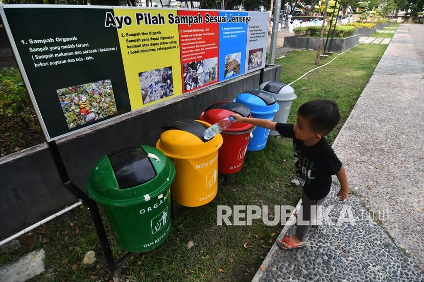 Seorang anak membuang sampah pada tempat sampah (ilustrasi). Dinas Lingkungan Hidup (DLH) Kota Bandung, Jawa Barat, tengah mencari solusi untuk meningkatkan perolehan retribusi sampah.