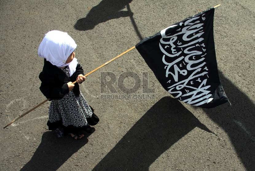  Seorang anak memegang bendera saat aksi unjuk rasa menolak RUU Ormas di depan komplek Parlemen, Jakarta, Jumat (5/4).  (Republika/Yasin Habibi)