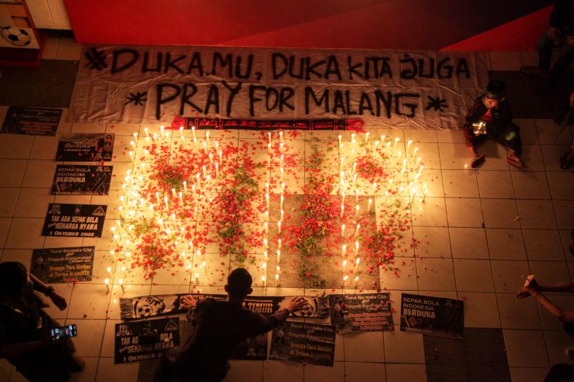 Seorang anak memegang lilin saat mengikuti doa bersama di Gelora Delta Sidoarjo, Jawa Timur, Selasa (4/10/2022). Doa bersama itu untuk para korban tragedi kerusuhan di Stadion Kanjuruhan, Malang. 