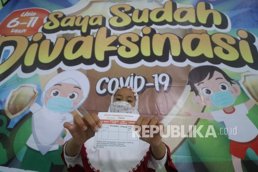 Seorang anak memperlihatkan kartu vaksinasi saat peluncuran vaksinasi COVID-19 untuk anak usia 6-11 tahun di Madrasah Ibtidaiyah Negeri 2 Kediri, Jawa Timur, Senin (20/12/2021). Vaksinasi COVID-19 bagi anak usia 6-11 tahun mulai dilaksanakan di Kabupaten Kediri dengan target 143 ribu anak dalam jangka waktu tiga bulan. 