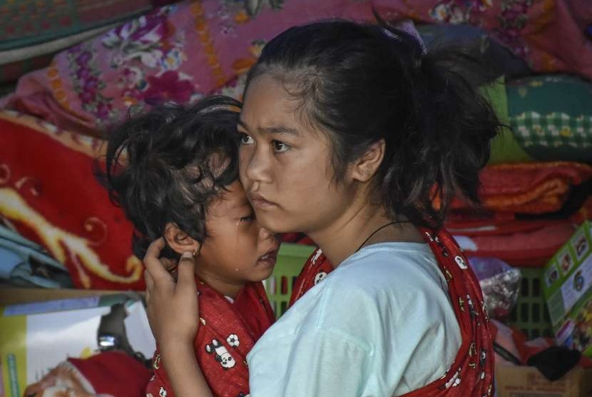 Seorang anak menangis dipelukan ibunya di Posko pengungsian korban gempa bumi Desa Sajang, Kecamatan Sembalun, Selong, Lombok Timur, NTB, Kamis (2/8).
