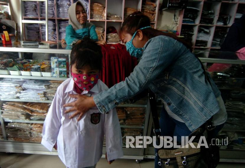 Seorang anak mencoba seragam sekolah di salah satu toko di Tegal, Jawa Tengah, Sabtu (11/7). Mahkamah Agung telah resmi membatalkan SKB Tiga Menteri tentang Pakaian Seragam dan Atribut para Peserta Didik, Pendidik, dan Tenaga Kependidikan.