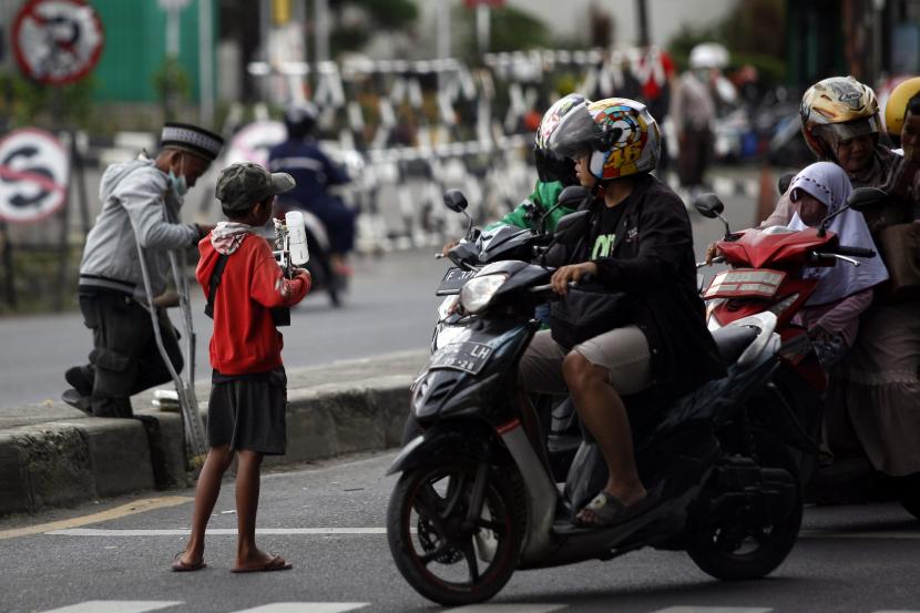 Seorang anak mengamen di perempatan Jalan Raya Bogor, Cibinong, Kabupaten Bogor, Jawa Barat, Jumat (28/10/2022). Lebih dari 3,3 juta pekerja paksa adalah anak-anak.
