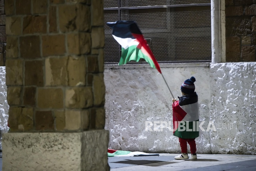 Seorang anak mengibarkan bendera Palestina saat demonstrasi solidaritas terhadap rakyat Palestina di tengah berlanjutnya konflik antara Israel dan Hamas, di Roma, Italia, 01 Desember 2023. 