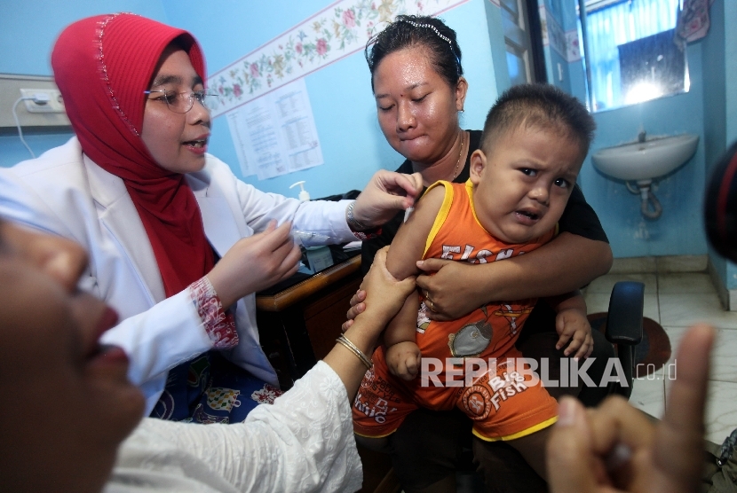 Seorang anak diberi vaksin.