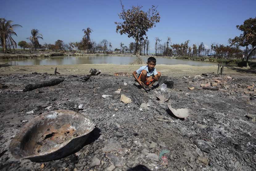  Seorang anak mengumpulkan potongan logam dari puing perkampungan Pauktaw yang dibakar dalam kekerasan baru-baru ini di Rakhine,Myanmar, Sabtu (27/10). (Soe Zeya Tun/Reuters) 