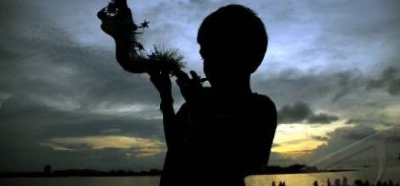 Seorang anak meniup terompet 'Naga' jelang perayaan tahun baru pada Sabtu ( 31/12).