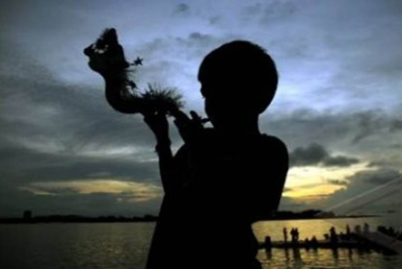 Seorang anak meniup terompet 'Naga' jelang perayaan tahun baru pada Sabtu ( 31/12).