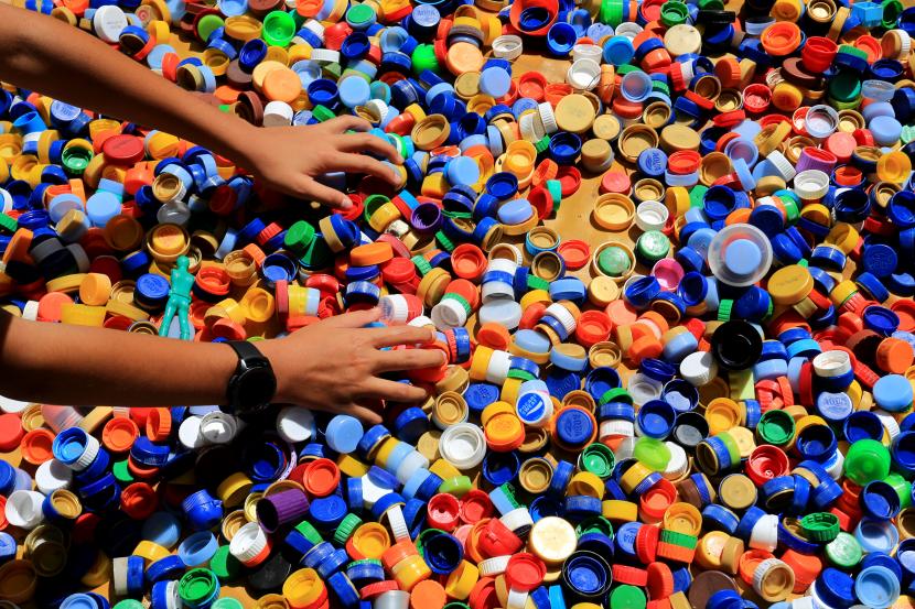 Seorang anak menjemur tutup botol saat edukasi pemanfaatan sampah botol plastik menjadi sofa di Desa Lampaseh Aceh, Meuraxa, Banda Aceh, Aceh, Senin (27/6/2022). Kabinet Jerman mendukung rancangan undang-undang pada Rabu (2/11/2022) yang akan mewajibkan produsen produk yang menggunakan plastik untuk membayar retribusi.