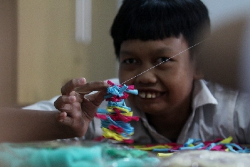 Seorang anak penderita lumpuh otak (Cerebral Palsy) berlatih keterampilan membuat taplak meja dan alas kaki di Sekolah SLB D/D1 Yayasan Pembinaan Anak Cacat (YPAC), Jakarta, Selasa (29/10). Pelatihan keterampilan ini untuk melatih koordinasi motorik halus 