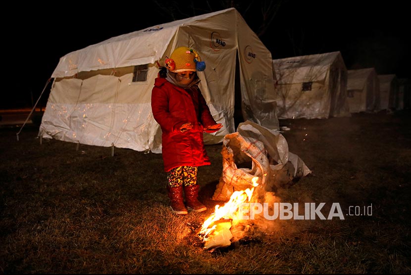 UNHCR: Turki Negara yang Tampung Jumlah Pengungsi Terbesar. Seorang anak pengungsi menghangatkan diri di dekat api di area tenda pengungsian di Elazig, Turki, Ahad (26/1). 