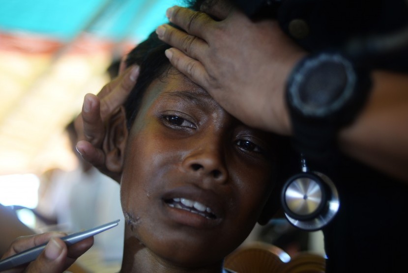 Seorang anak pengungsi Rohingya diperiksa lukanya oleh tenaga medis di tenda kesehatan Indonesia, Kamp Pengungsian Jamtoli, Cox's Bazar, Bangladesh. 
