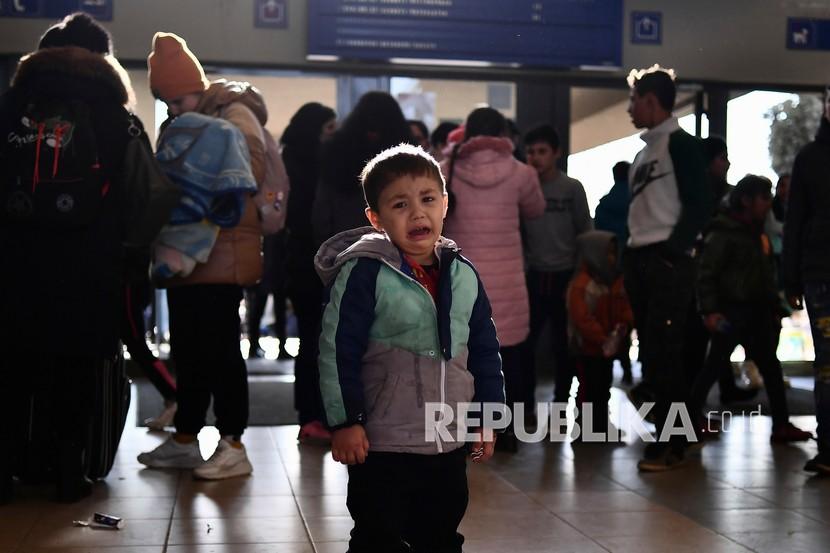 Seorang anak pengungsi yang melarikan diri dari konflik dari negara tetangga Ukraina menangis di stasiun kereta api setelah tiba di Zahony, Hongaria, Ahad, 27 Februari 2022. Sebanyak 25 warga negara Indonesia (WNI) yang berada di Odessa, Ukraina, telah dievakuasi ke Bukares, Rumania.