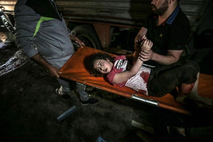 Seorang anak perempuan yang terluka akibat dampak serangan udara Israel di Jalur Gaza, Ahad (16/5), ditandu untuk segera bisa mendapat pengobatan.