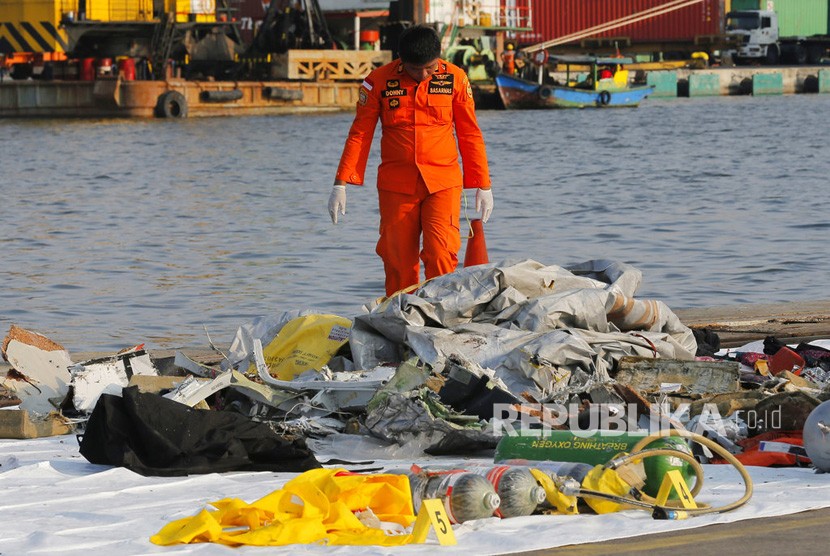 Seorang anggota Basarnas memeriksa puing pesawat Lion Air JT 610 pascakecelakaan,di Pelabuhan Tanjung Priok Jakarta, Senin (29/10/2018).