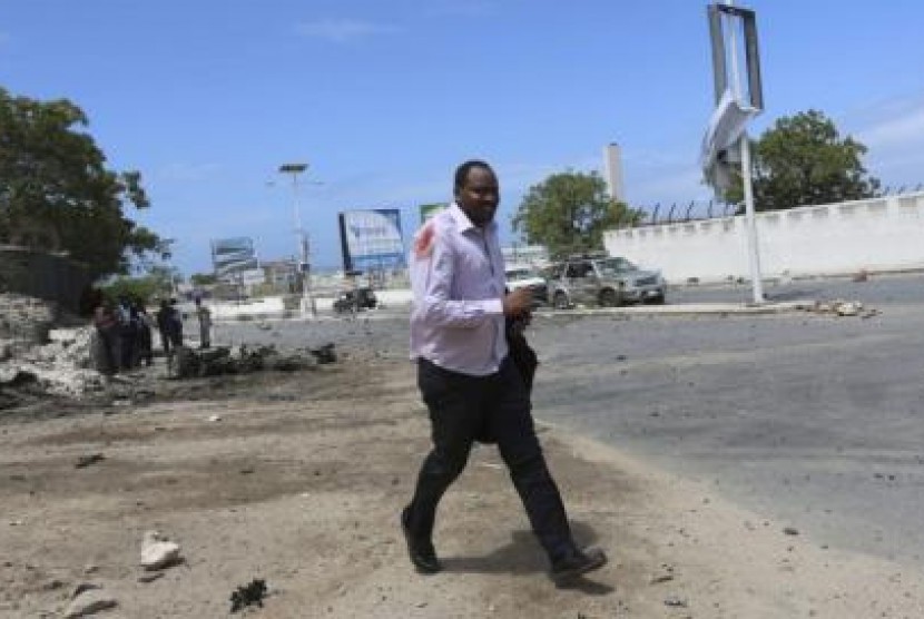 Seorang anggota dewan berjalan keluar usai insiden baku tembak di gedung parlemen Somalia.