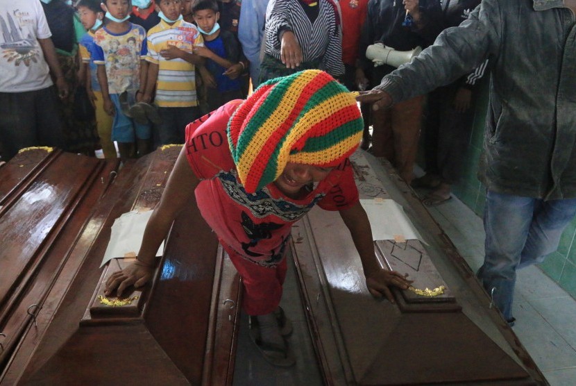 Seorang anggota keluarga korban awan panas erupsi Gunung Sinabung menangis didekat peti jenazah, sebelum dimakamkan di Desa Sukandebi, Karo, Sumatera Utara, Minggu (22/5).
