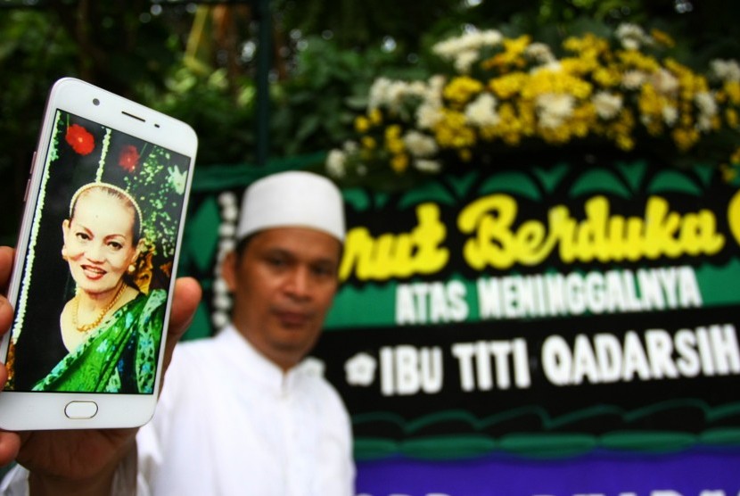 Seorang anggota keluarga menunjukan foto semasa hidup almarhumah Titi Qadarsih di rumah duka di Sawangan, Depok, Jawa Barat, Senin (22/10/2018). Titi Qadarsih yang merupakan penyanyi dan aktris film senior Indonesia meninggal dunia dalam usia 73 tahun pada Senin (22/10) karena sakit. 