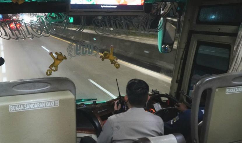 Seorang anggota kepolisian mengawal dari dalam sebuah bus yang melintas di ruas tol Semarang- Solo (arah Semarang) guna mengantisipasi gangguan keamanan berupa aksi pelemparan batu oleh orang tak dikenal di rusa tol ini.