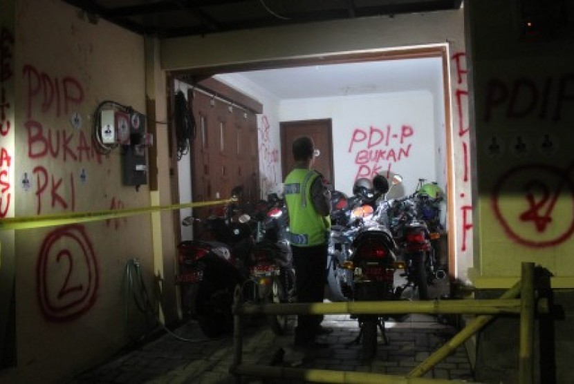 Seorang anggota kepolisian mengecek kerusakan yang terjadi di kantor Tv One Biro Yogyakarta, Rabu (2/7) malam. 