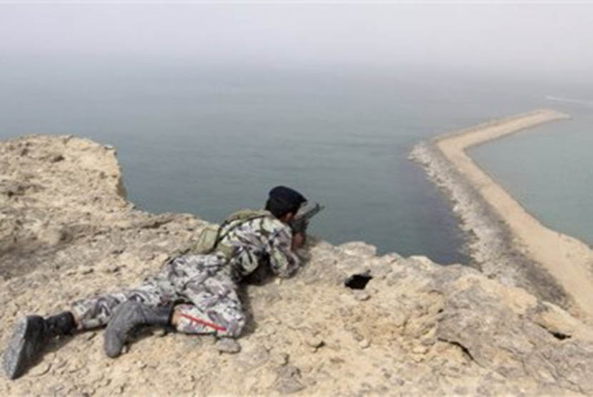 Seorang anggota militer Iran mengambil posisi siaga di pengeboran minyak Iran di pantai laut Oman. 