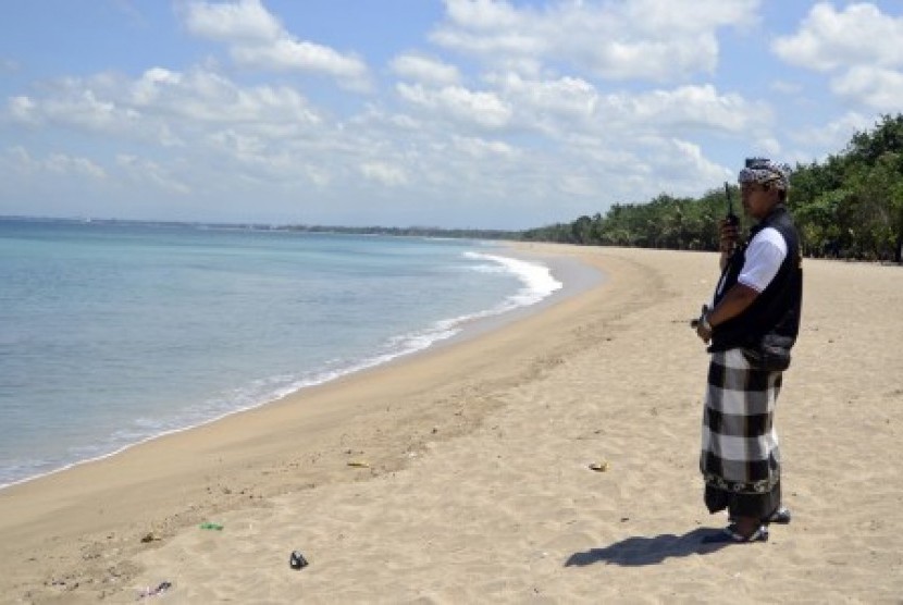 Seorang anggota Pecalang atau satuan pengamanan adat Bali berkomunikasi dengan rekannya saat memantau situasi pantai saat pelaksanaan Hari Raya Nyepi di Pantai Kuta, Bali. (ilustrasi)