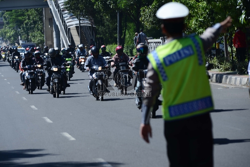 Seorang anggota Polisi mengatur lalu lintas untuk kanalisasi motor di Jalan Gatot Subroto, Jakarta Selatan, Rabu (18/3). (Republika/Raisan Al Farisi)