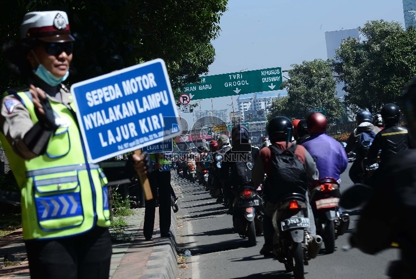 Seorang anggota Polisi mengatur lalu lintas di Jalan Gatot Subroto, Jakarta Selatan.