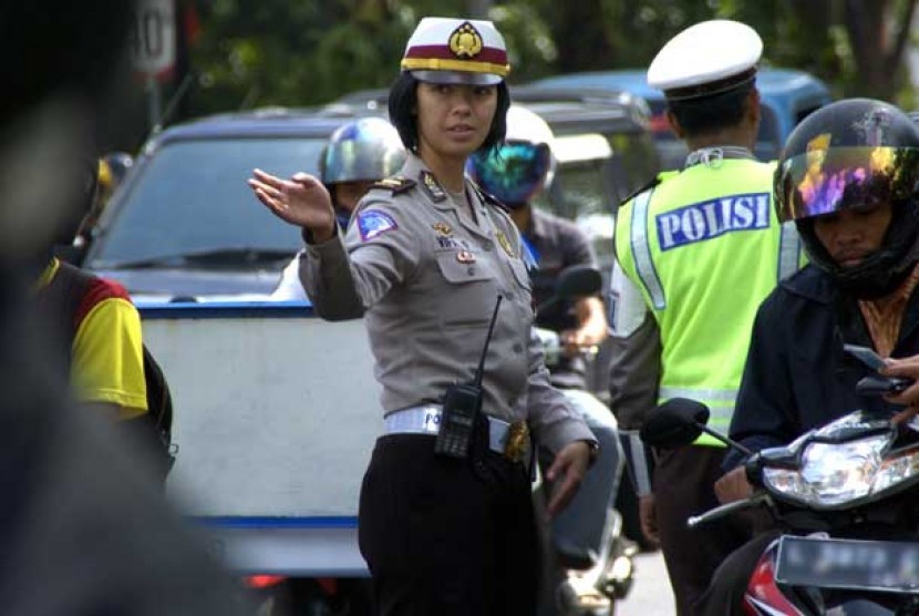 Seorang anggota polwan tengah mengatur arus lalu lintas.  (ilustrasi)