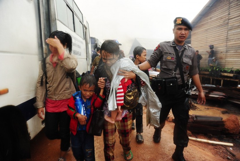  Anggota Brimob Polda Kalbar mendampingi warga eks-Gafatar saat dievakuasi dari permukiman mereka yang dibakar massa di kawasan Monton Panjang, Dusun Pangsuma, Desa Antibar, Mempawah Timur, Kabupaten Mempawah, Selasa (19/1).(Antara/Jessica Helena Wuysang)