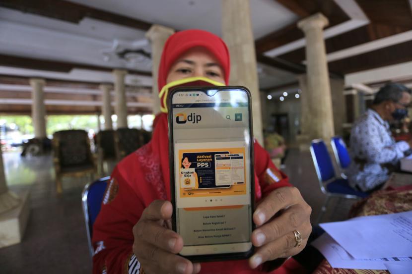 Seorang Aparatur Sipil Negara (ASN) menunjukkan aplikasi pelaporan Surat Pemberitahuan (SPT) Tahunan Pajak 2021 di Pendopo Indramayu, Jawa Barat, Kamis (10/3/2022). Batas akhir lapor surat pemberitahuan tahunan wajib pajak orang pribadi pada 31 Maret 2023.