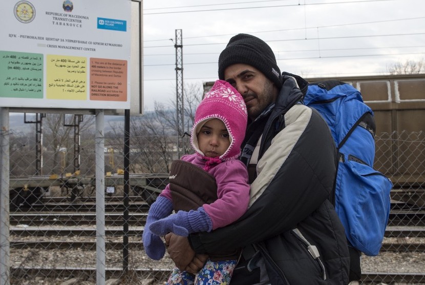 Seorang ayah dan anaknya merupakan pengungsi dari Suriah, berjalan menuju perbatasan Serbia dari pusat transit bagi para pengungsi di dekat desa Tabanovce, Kumanovo, Republik Yugoslavia, (4/2). 