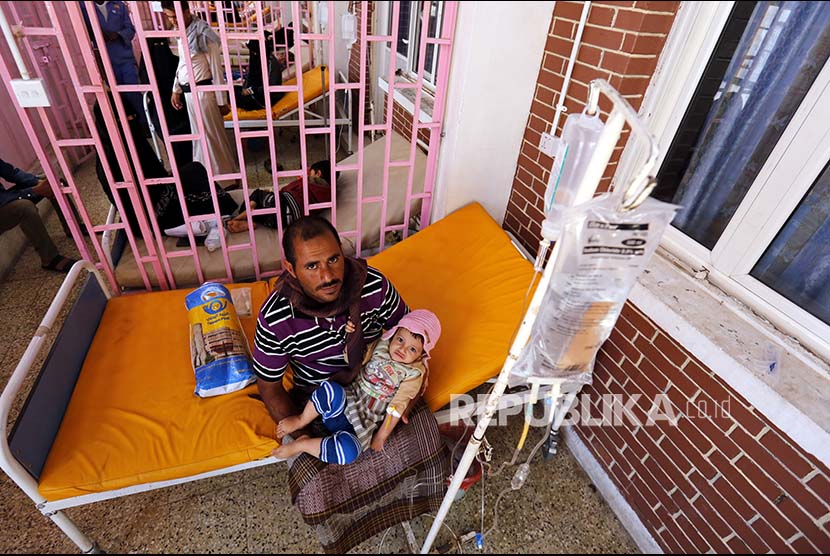 Seorang ayah menggendong anaknya yang dirawat di sumah sakit setempat karena wabah Kolera. Kementerian Kesehatan Suriah mencatat 39 kematian akibat kolera.