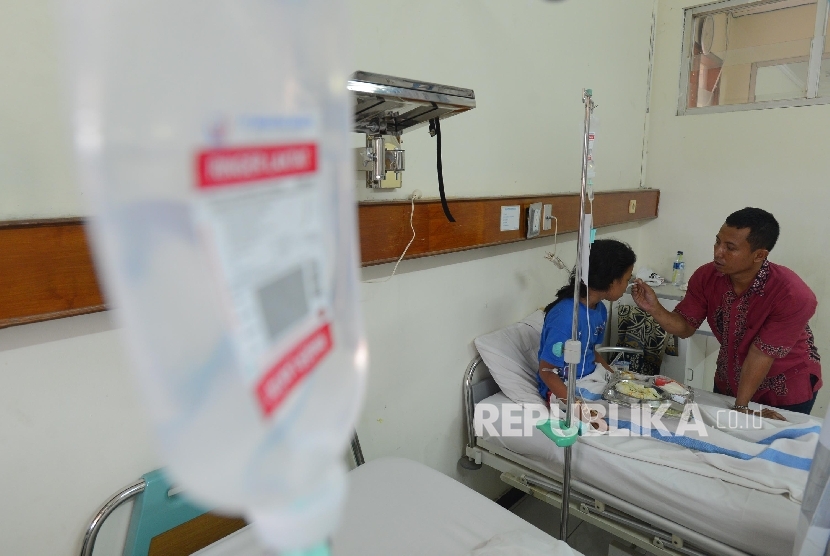  Seorang ayah merawat anaknya yang terkena virus Demam Berdarah Dengue (DBD) di sebuah rumah sakit. ilustrasi
