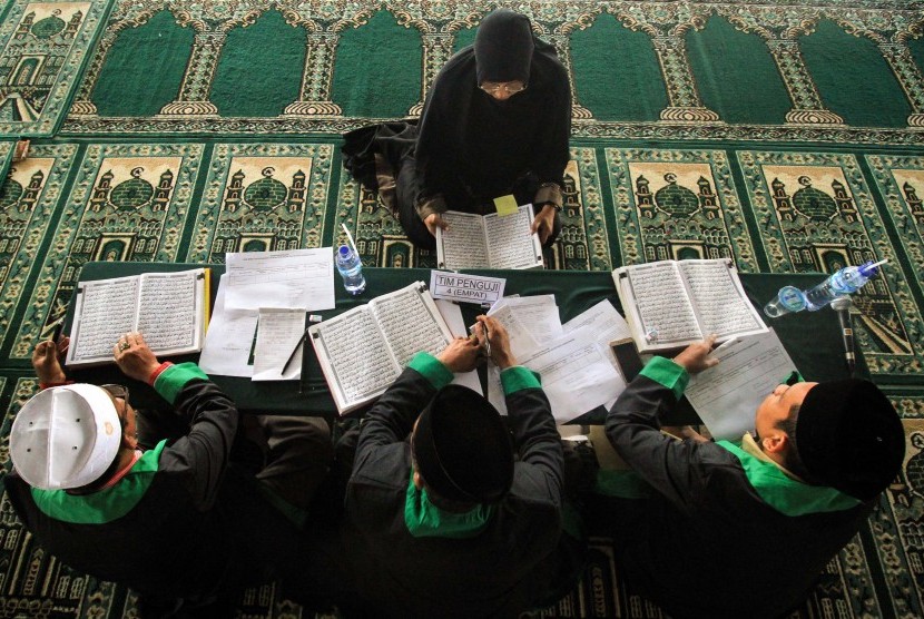 Seorang Bakal Calon Legislatif (bacaleg) perwakilan perempuan mengikuti uji mampu baca Alquran yang dilaksanakan oleh Komisi Independen Pemilihan (KIP) Lhokseumawe di Masjid Agung Islamic Centre, Kota Lhokseumawe, Aceh, Senin (16/7). 