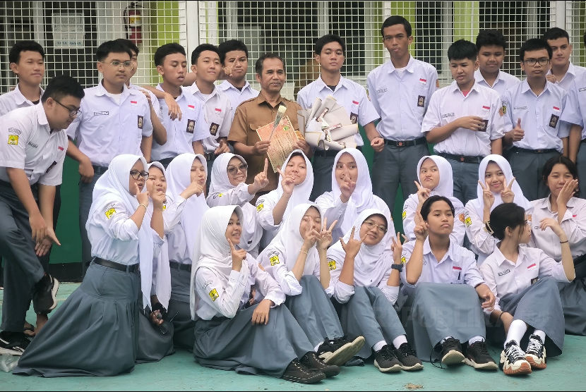 Seorang guru berfoto dengan siswa-siswanya di sela peringatan Hari Guru Nasional di SMAN 12 Bandung, Senin (27/11/2023). Penghapusan jurusan IPA, IPS, dan Bahasa masih menuai pro dan kontra.