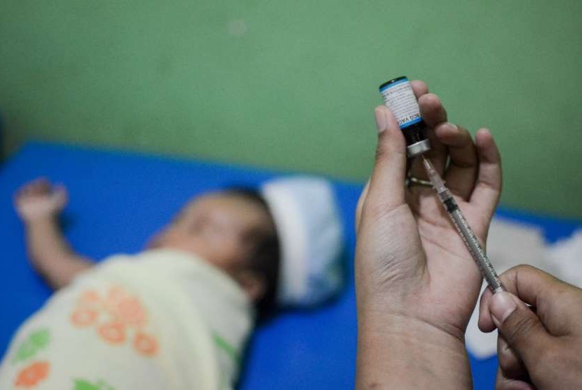 Seorang Bidan menyiapkan vaksin untuk disuntikkan kepada balita saat imunisasi di Rancamaya, Bogor Selatan, Jawa Barat, Kamis (23/8).