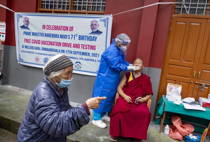 Seorang biksu Buddha Tibet di pengasingan diuji untuk COVID-19 di sebuah kamp yang diselenggarakan untuk merayakan ulang tahun perdana menteri India Narendra Modi di Dharmsala, India, Jumat, 17 September 2021.