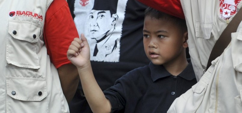 Seorang bocah berada di antara sejumlah anggota PDIP mengikuti upacara bendera memperingati Hari Kelahiran Pancasila di DPP PDIP, Lenteng Agung, Jakarta, Rabu (1/6).