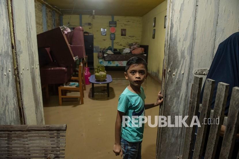 Seorang bocah berada di dalam rumahnya yang terendam banjir di Desa Garot Cut Kecamatan Indrajaya, Kabupaten Pidie, Aceh, Senin (17/1/2022). Banjir tersebut akibat curah hujan yang tinggi sehingga menyebabkan sungai krueng baro di Kabupaten Pidie, Aceh meluap.