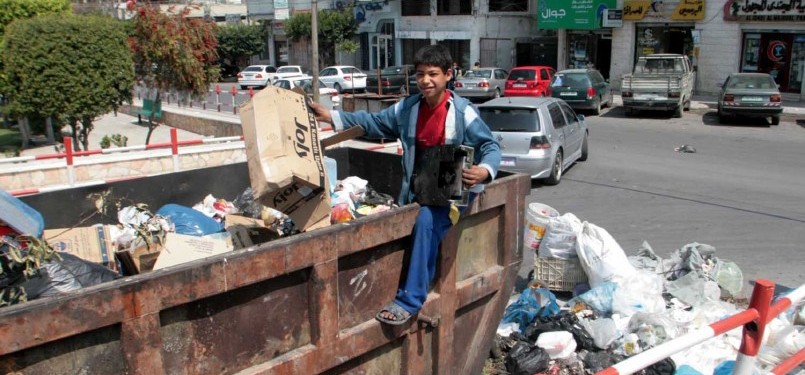 Seorang bocah di Jalur Gaza mencari nafkah sebagai tukang pengangkut sampah.