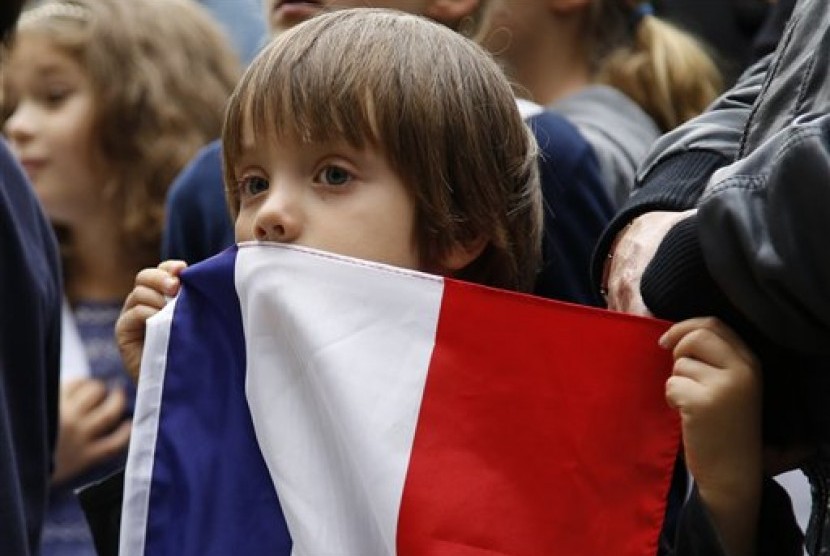 Seorang bocah laki-laki memegang bendera Prancis. Perselisihan diplomatik antara Prancis dan China semakin melebar di tengah pandemi. Ilustrasi.
