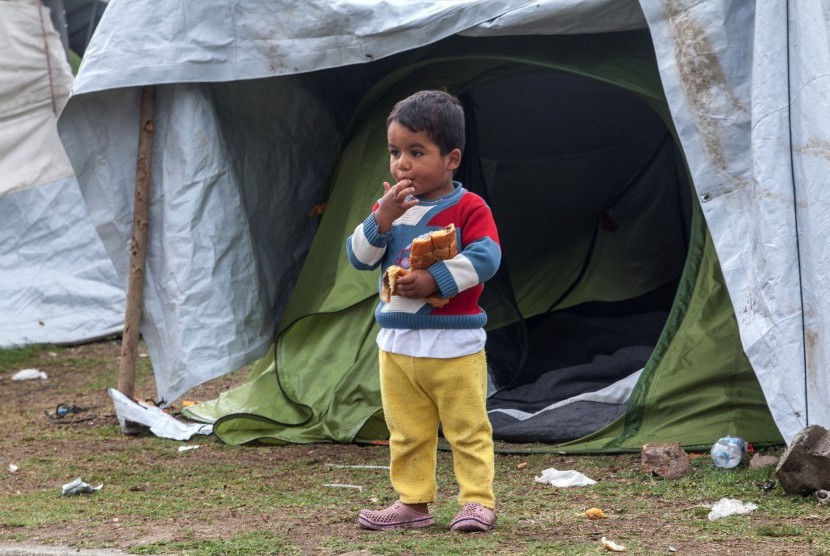 Seorang bocah laki-laki pengungsi suriah berdiri di depan tenda penampungan di desa Polykastro, utara Yunani. (ilustrasi) 