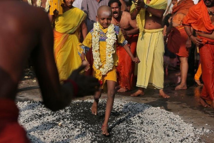 Seorang bocah lelaki plontas berjalan do atas bara api dalam acara Perayaan Thaipusam di Chennai.