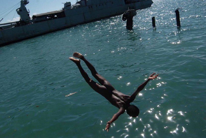 Seorang bocah melompat diantara KRI Teluk Cirebon 543 saat mandi dilaut di pantai Kaimana ,Papua Barat.