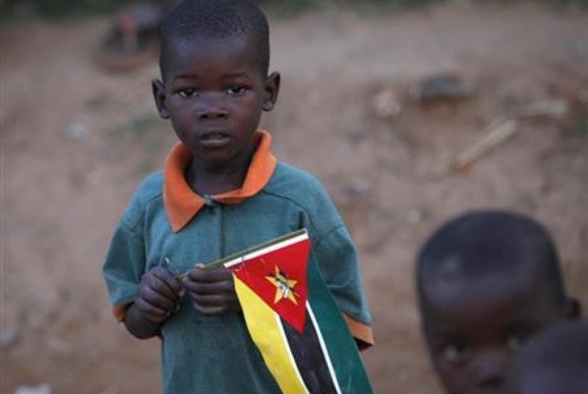 Seorang bocah memegang bendera Mozambik di pinggiran ibu kota Maputo.